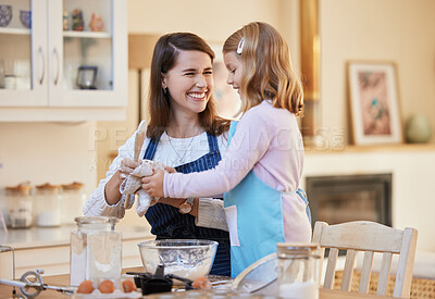 Buy stock photo Shot of a young woman cleaning her daughters hands while they bake together