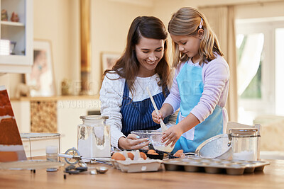 Buy stock photo Shot of a young woman helping her daughter stir a bowl of cake batter