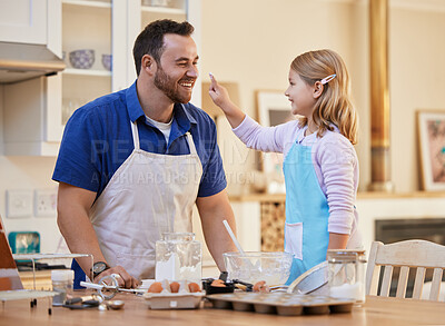 Buy stock photo Shot of a young father and daughter playing around while baking