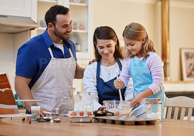 Buy stock photo Shot of a family baking together while a little girl stirs a bowl of cake batter