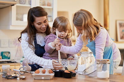 Buy stock photo Shot of a young mother baking with her daughters