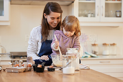 Buy stock photo Shot of a young woman helping her daughter stir a bowl of batter