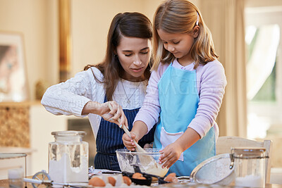 Buy stock photo Shot of a mother helping her daughter stir a bowl of cake batter