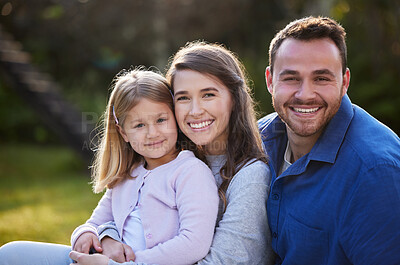 Buy stock photo Cropped portrait of an affectionate young family of three posing in the garden at home