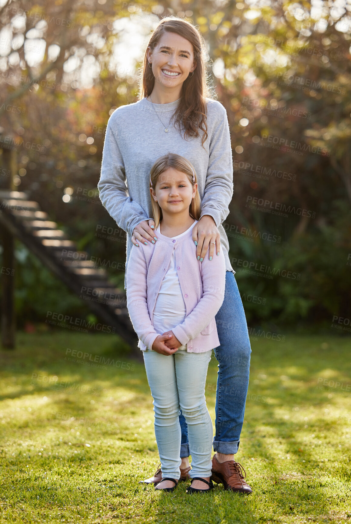 Buy stock photo Full length portrait of an attractive young woman and her daughter posing outside in the garden at home