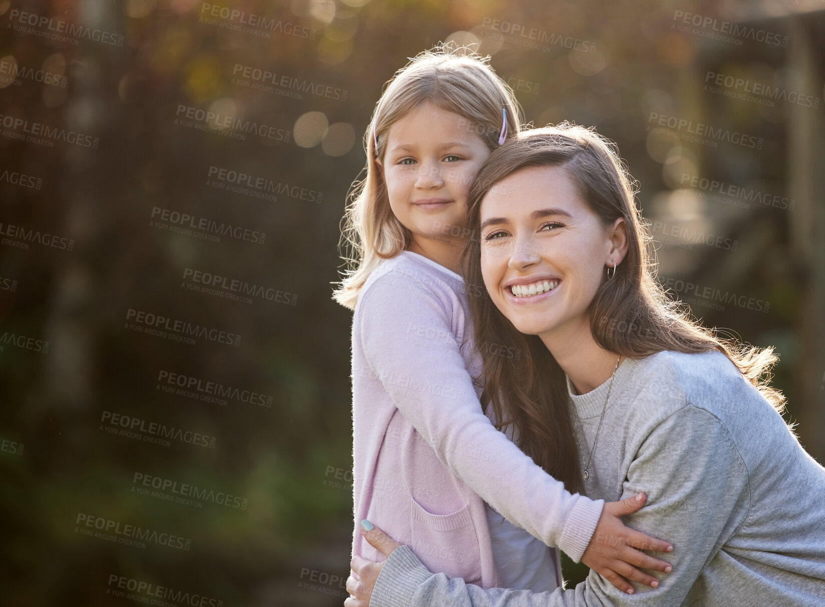 Buy stock photo Cropped portrait of an attractive young woman and her daughter posing outside in the garden at home