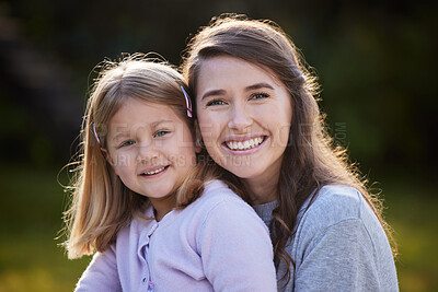Buy stock photo Cropped portrait of an attractive young woman and her daughter posing outside in the garden at home