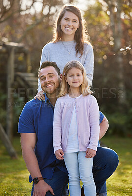 Buy stock photo Cropped portrait of an affectionate young family of three posing in the garden at home