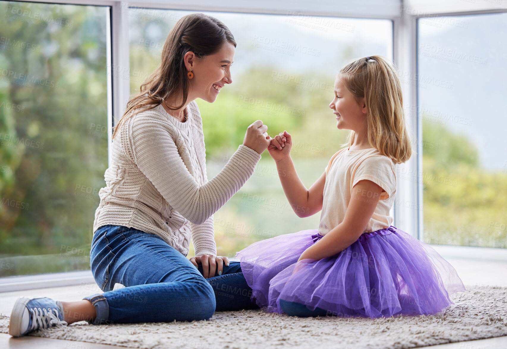 Buy stock photo Shot of a young mother and daughter making a pinky promise at home