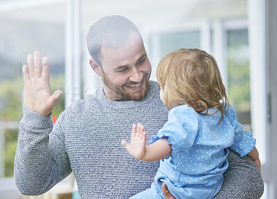 Buy stock photo Shot of a young father and daughter touching a window at home