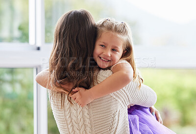 Buy stock photo Shot of a little girl giving her mother a hug at home