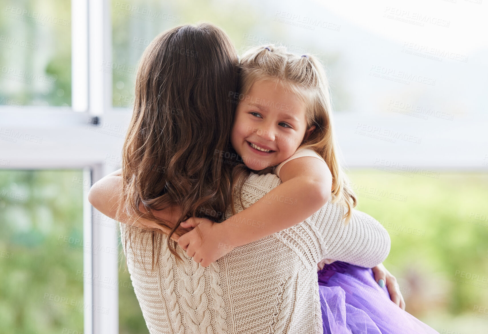 Buy stock photo Shot of a little girl giving her mother a hug at home