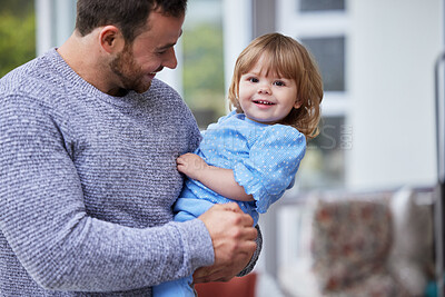 Buy stock photo Shot of a young father and daughter relaxing at home