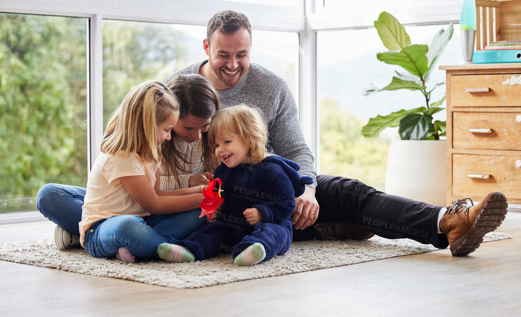 Buy stock photo Shot of a young family playing together at home