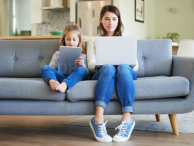 Buy stock photo Shot of a young mother and daughter using a laptop and digital tablet on the couch at home