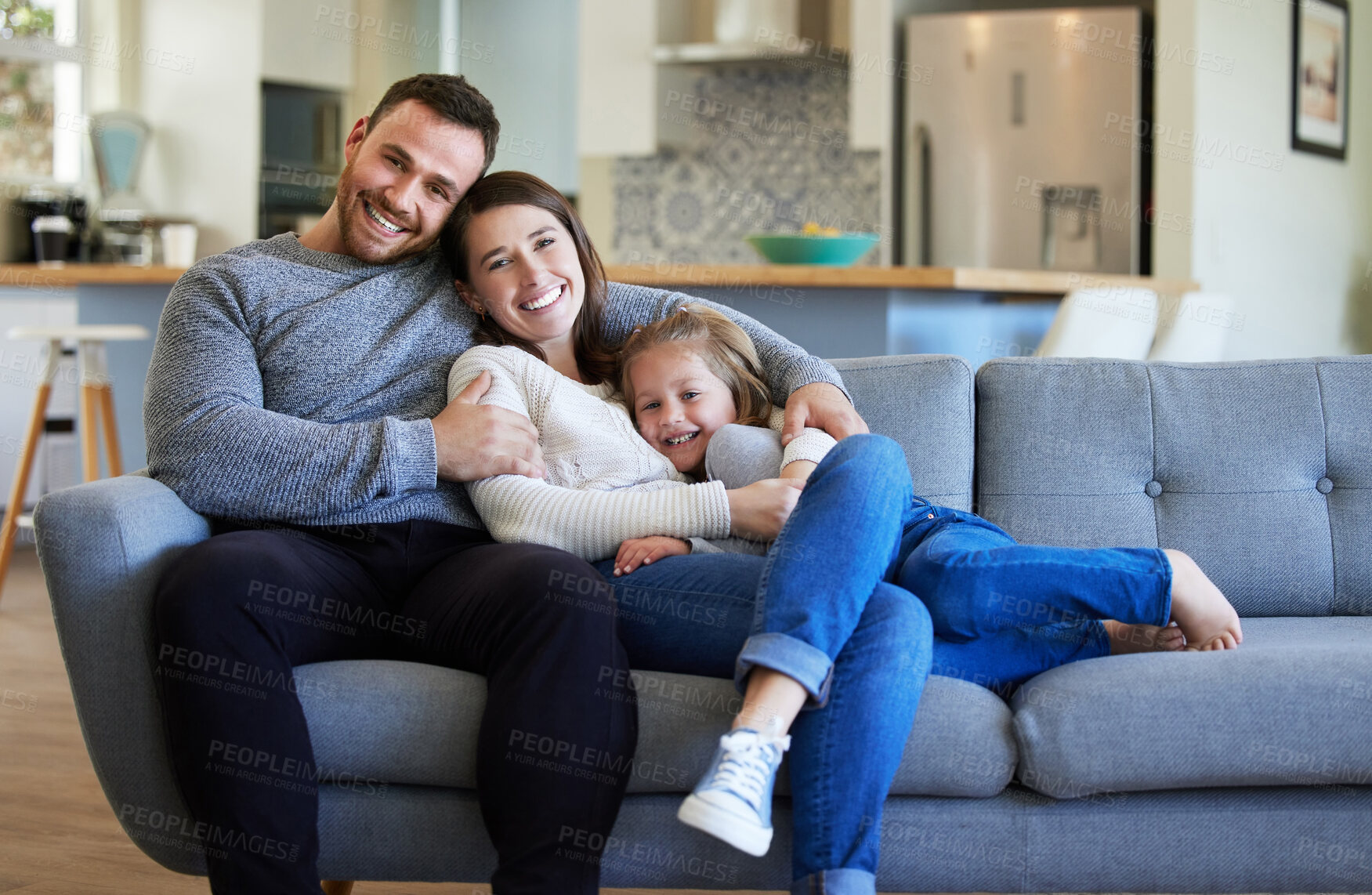 Buy stock photo Shot of a young family relaxing on the couch at home