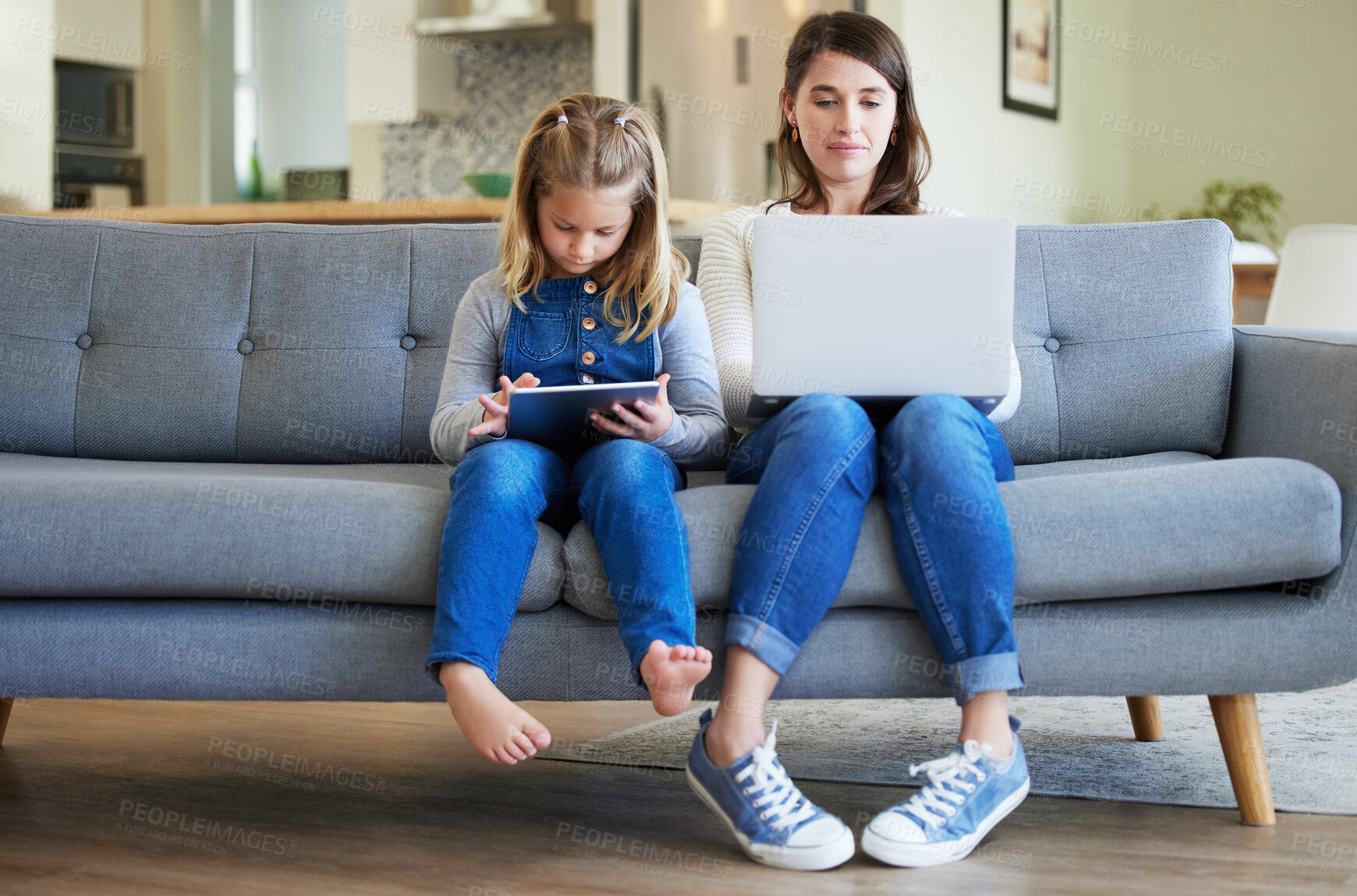Buy stock photo Shot of a young mother and daughter using a laptop and digital tablet on the couch at home