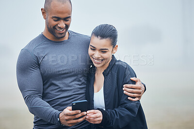 Buy stock photo Shot of a young couple spending time together during training while using a smartphone