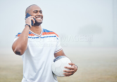 Buy stock photo Shot of a young male soccer player making a phone call while holding a soccer ball