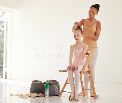 Buy stock photo Shot of a ballerina helping a younger girl style her hair in a dance studio