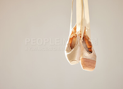 Buy stock photo Shot of a pair on ballet shoes hanging in a dance studio