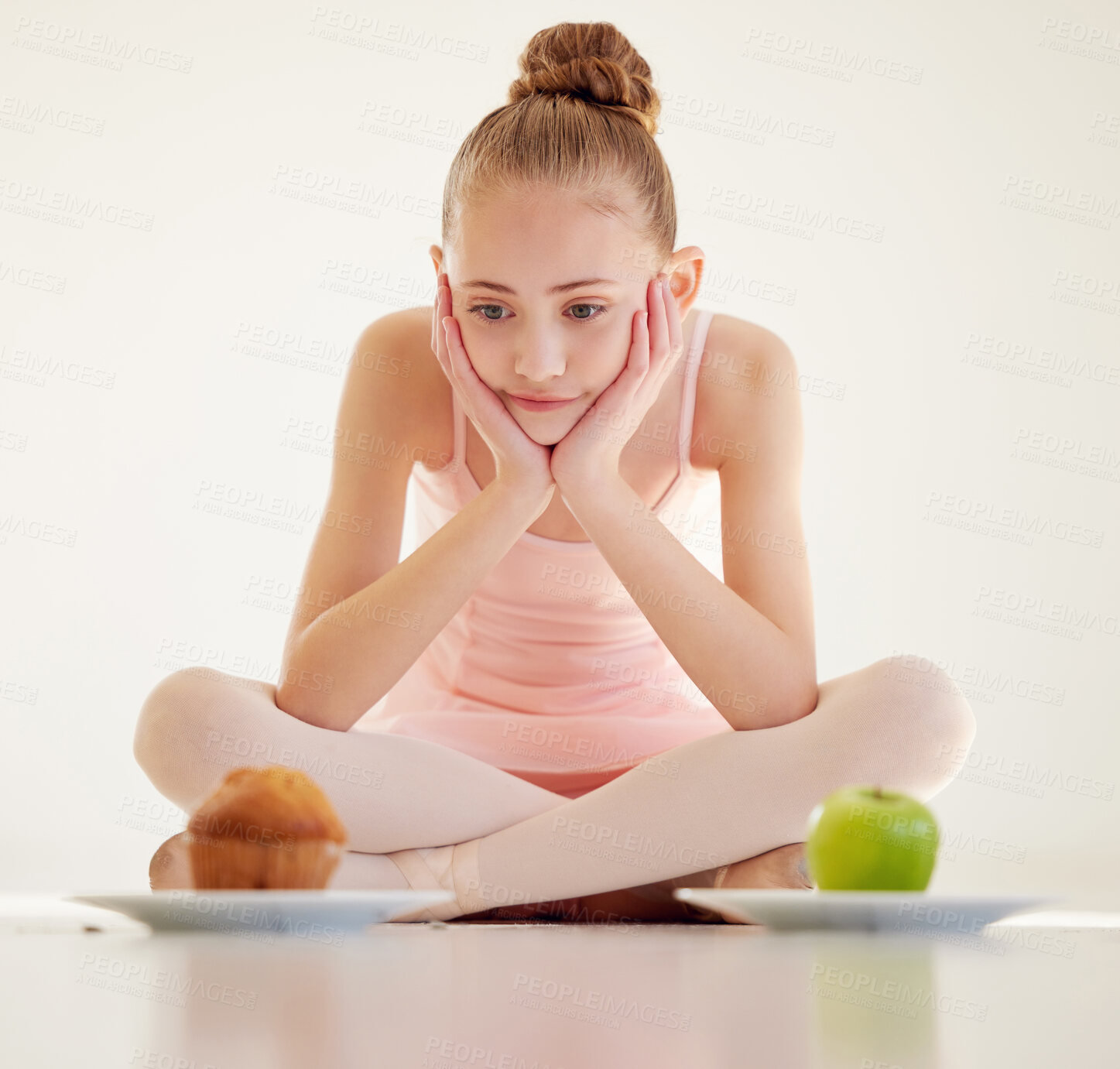 Buy stock photo Shot of a young ballerina  deciding what to eat in a studio