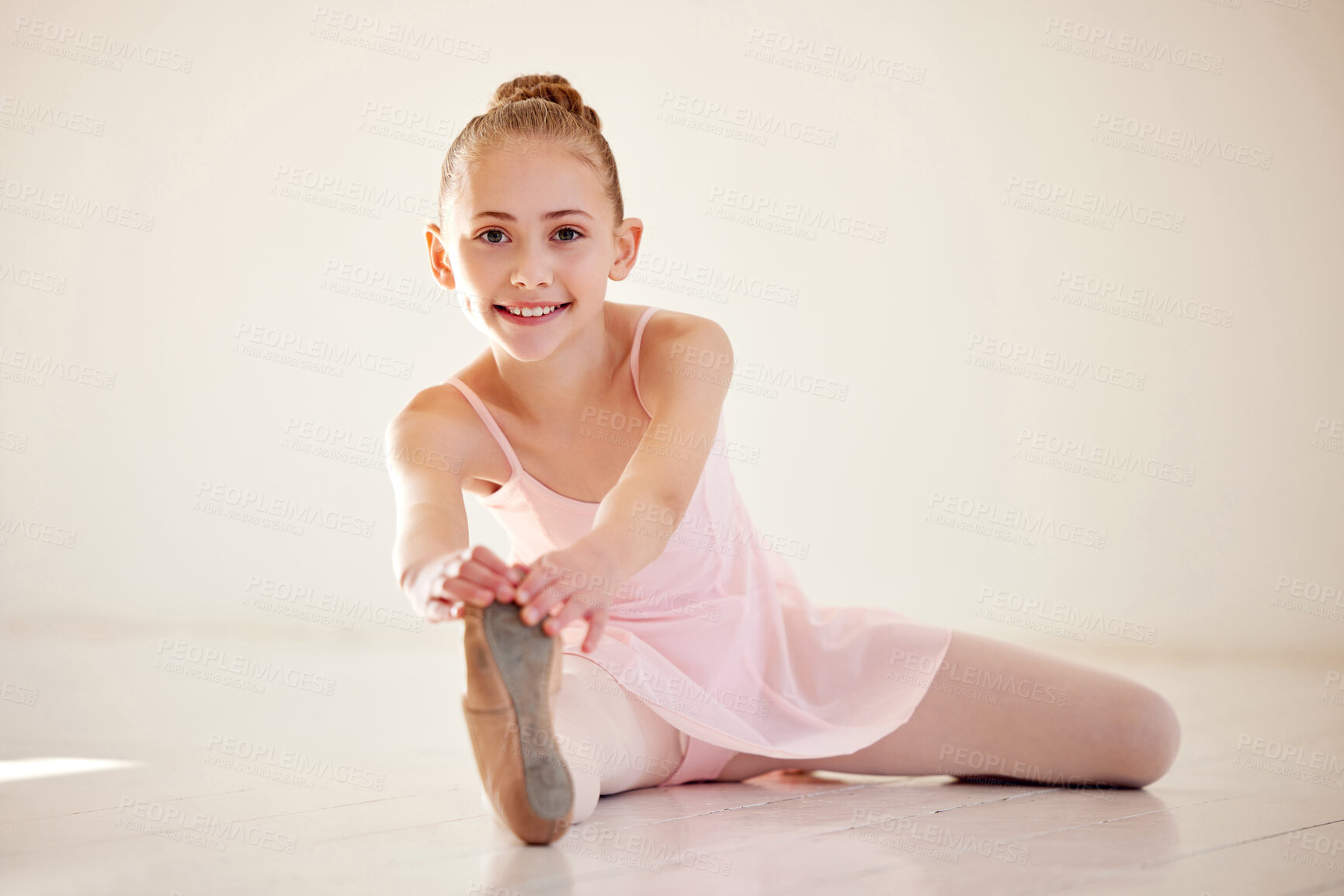 Buy stock photo Shot of a young ballerina stretching on the floor in a studio