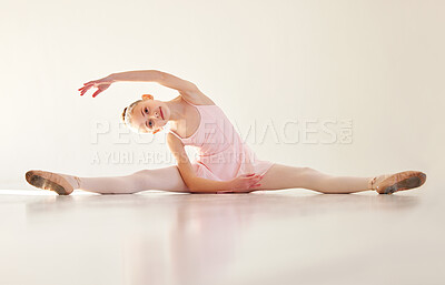 Buy stock photo Shot of a young ballerina stretching in a dance studio