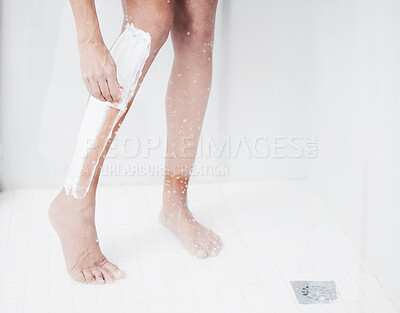 Buy stock photo Shot of a woman shaving her legs in the shower