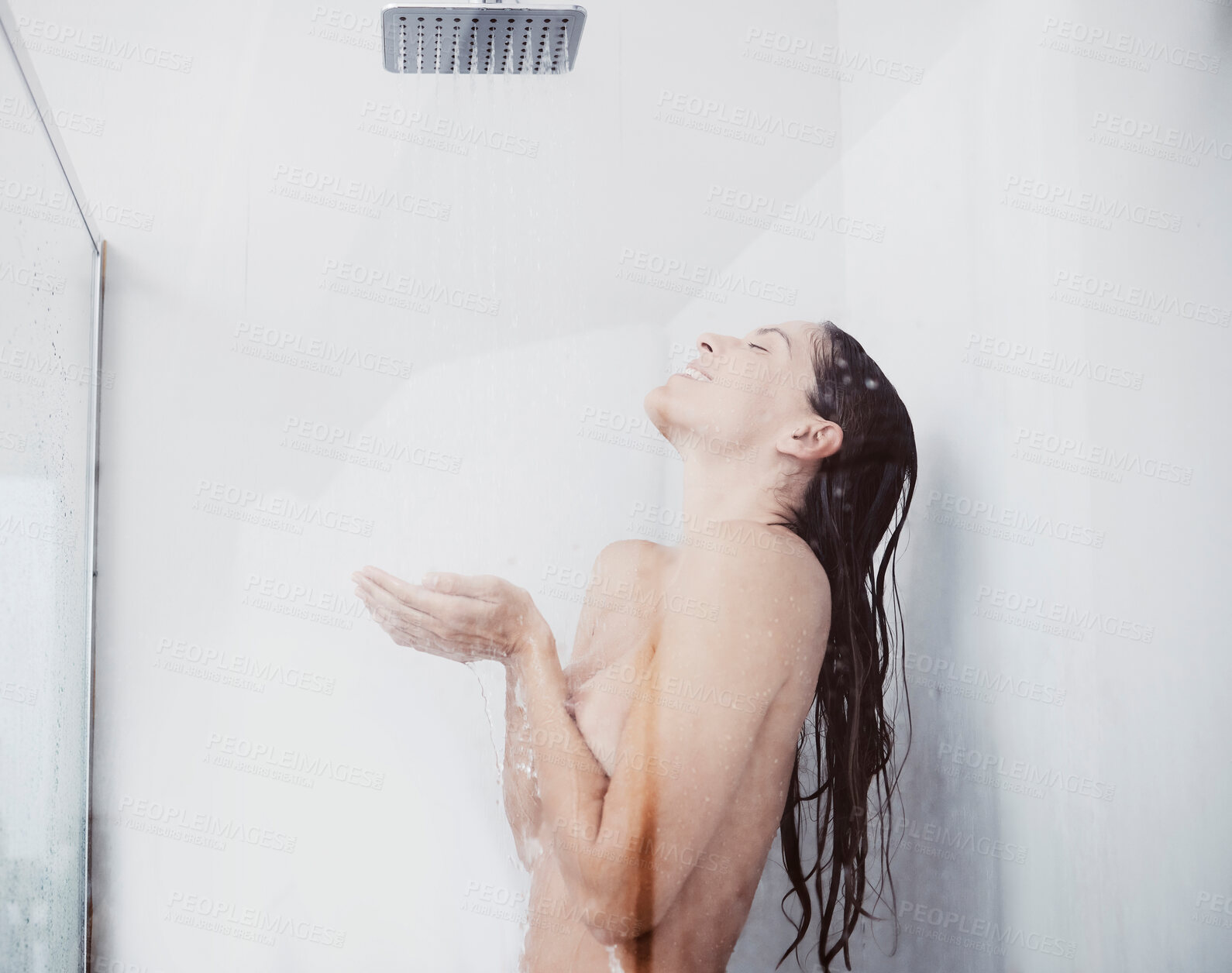 Buy stock photo Shot of a young woman taking a shower