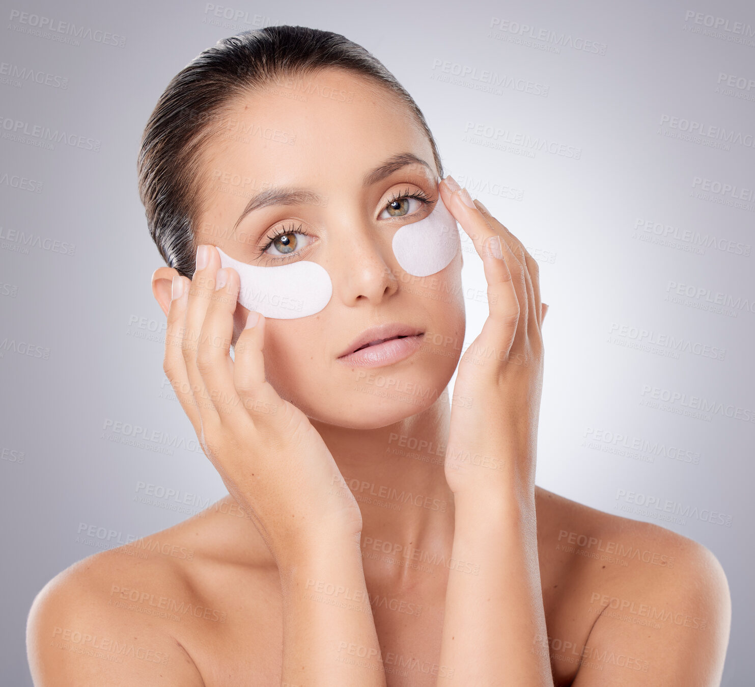Buy stock photo Shot of a young beautiful woman wearing under-eye patches against a grey background