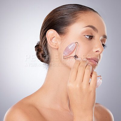 Buy stock photo Skincare, woman and facial roller for wellness, blood circulation and beauty in studio. Model girl, dermatology and crystal tool for face massage, lymphatic drainage and collagen by gray background