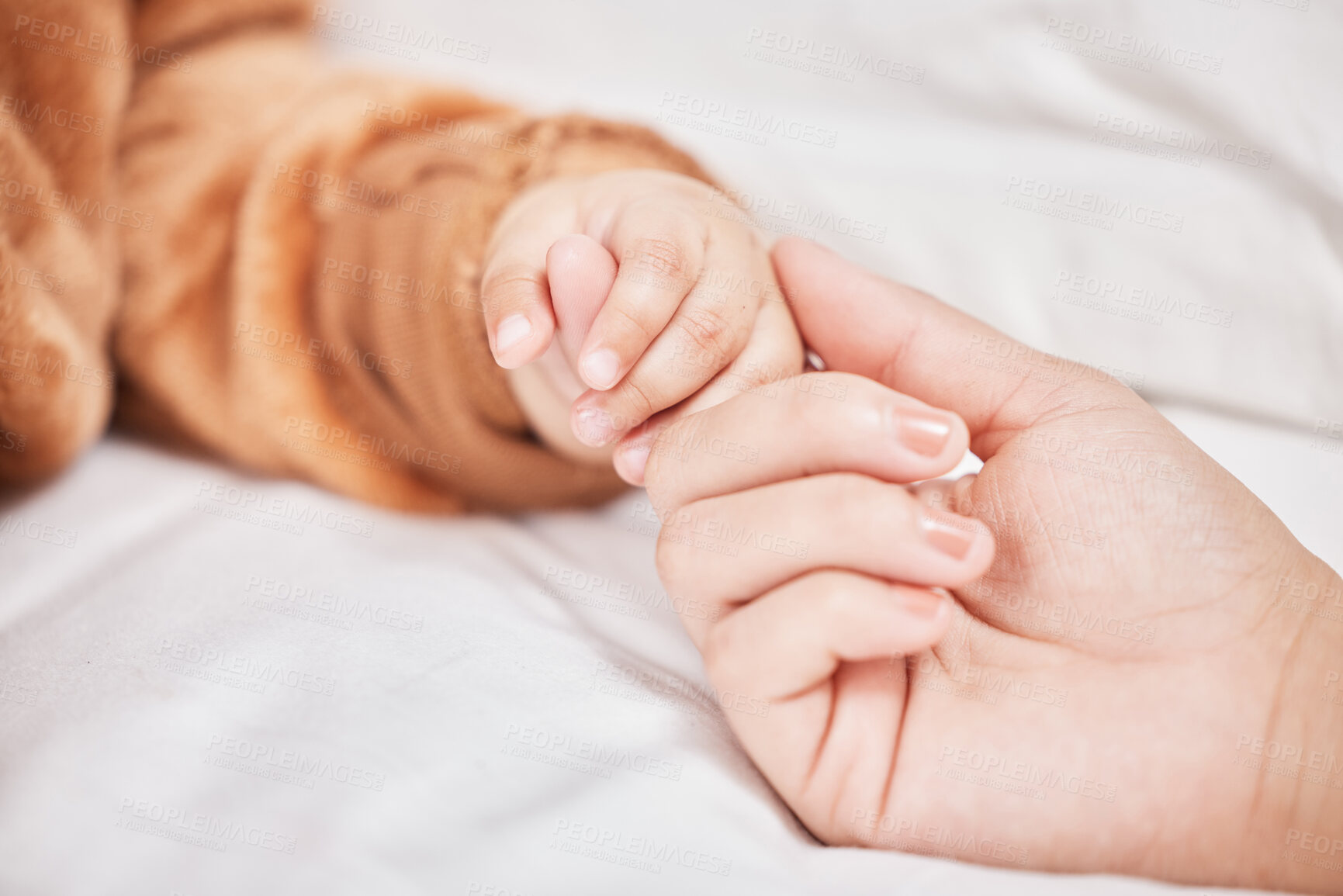 Buy stock photo Shot of a mother holding her sons hand while he sleeps