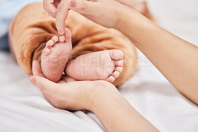 Buy stock photo Shot of a young mother holding her sons feet while he sleeps