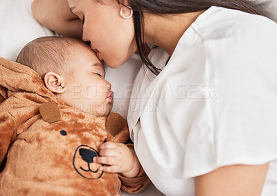 Buy stock photo Shot of a young mother kissing her sons forehead while he sleeps