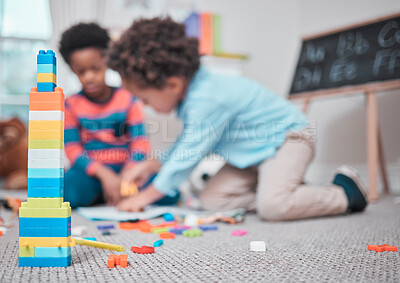 Buy stock photo Shot of two young boys playing with building blocks in a room