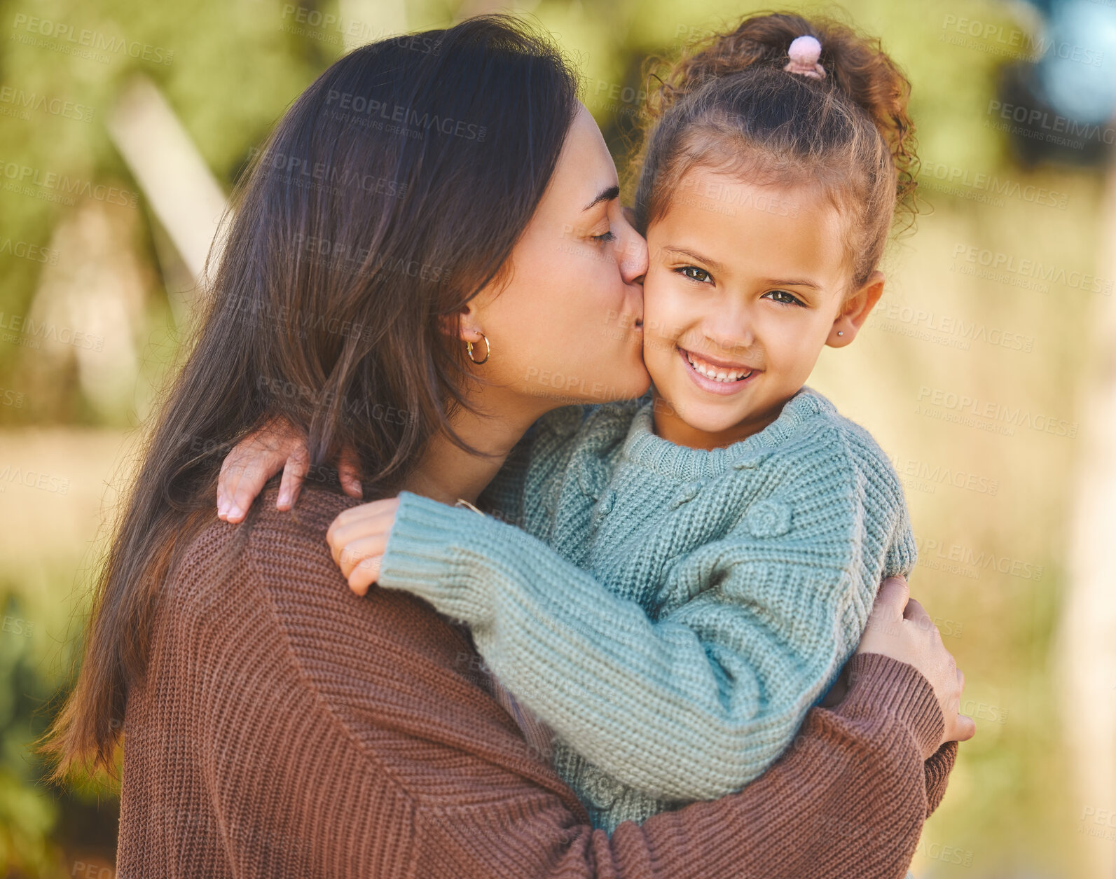 Buy stock photo Shot of a young mother affectionately kissing her daughter on the cheek