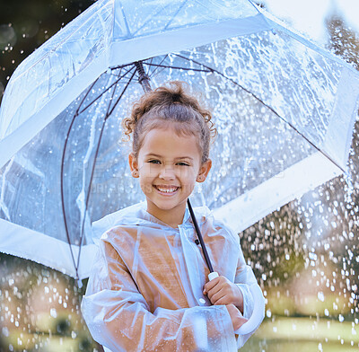 Buy stock photo Shot of a little girl playfully standing in the rain holding her umbrella
