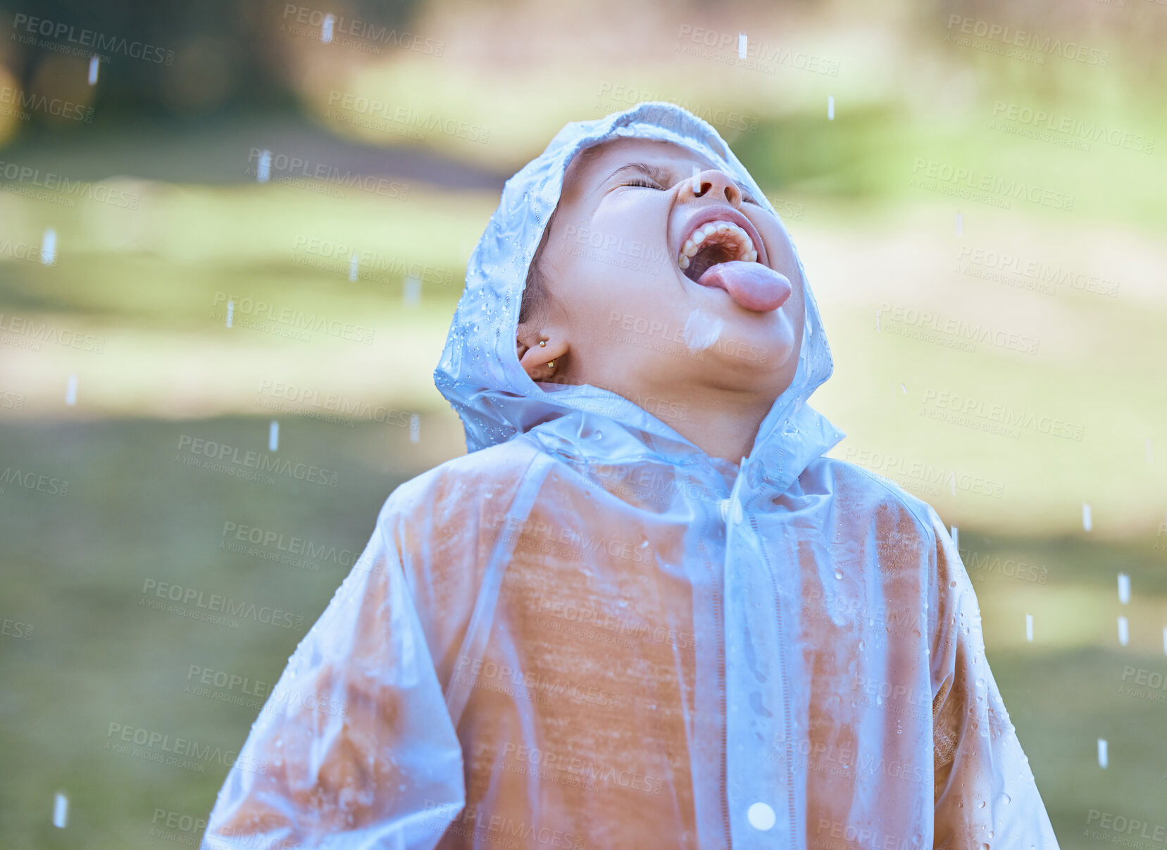 Buy stock photo Shot of a little girl sticking her tongue out to catch the rain drops in her mouth
