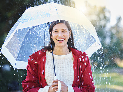 Buy stock photo Shot of a young woman holding an umbrella in the rain outside