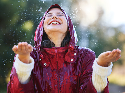 Buy stock photo Shot of a young woman enjoying the rain outside