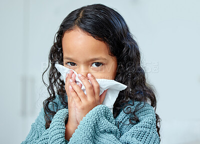 Buy stock photo Shot of a little girl blowing her nose at home
