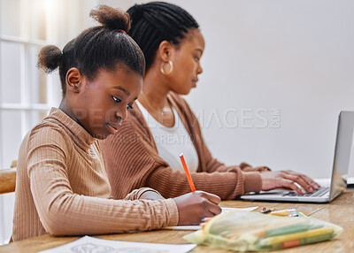Buy stock photo Shot of a young mother using a laptop while her daughter does homework at home