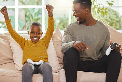 Buy stock photo Shot of a little boy cheering in excitement while gaming with his father
