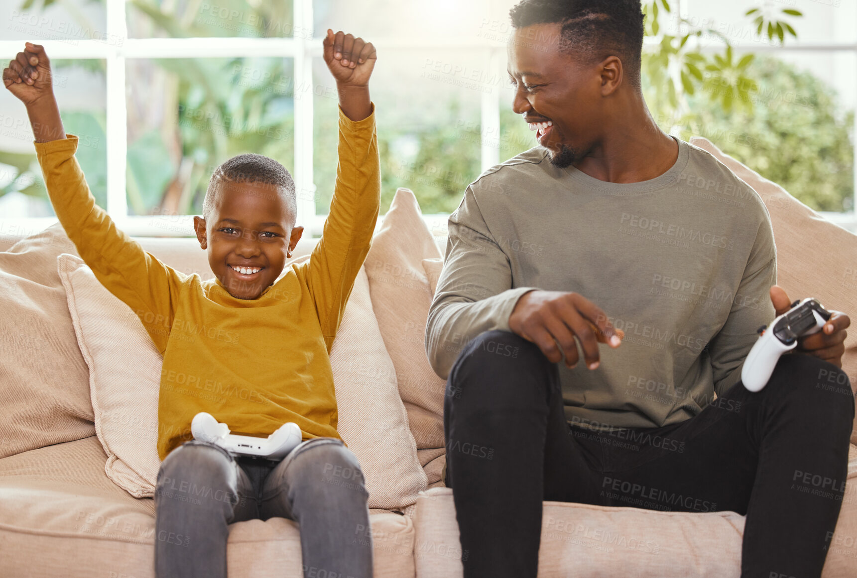 Buy stock photo Shot of a little boy cheering in excitement while gaming with his father
