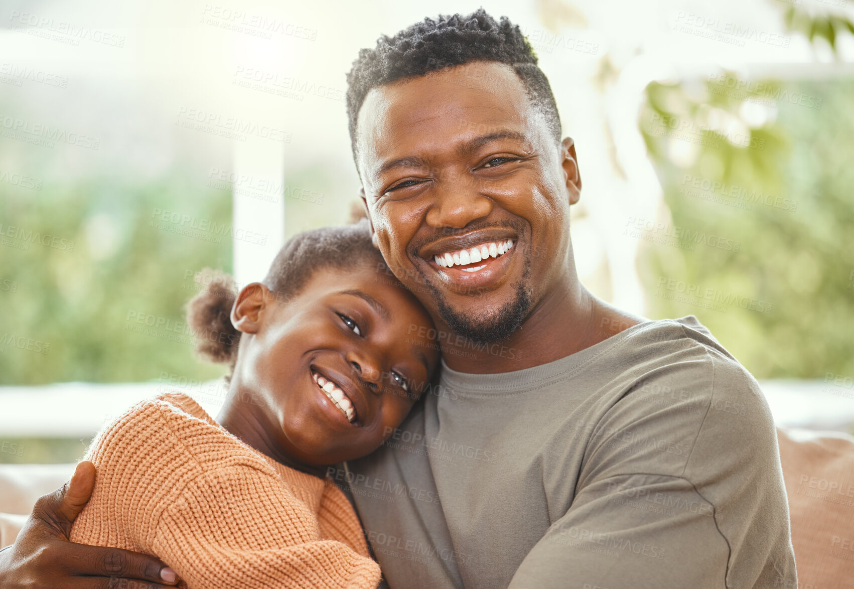 Buy stock photo Shot of a young father embracing his daughter
