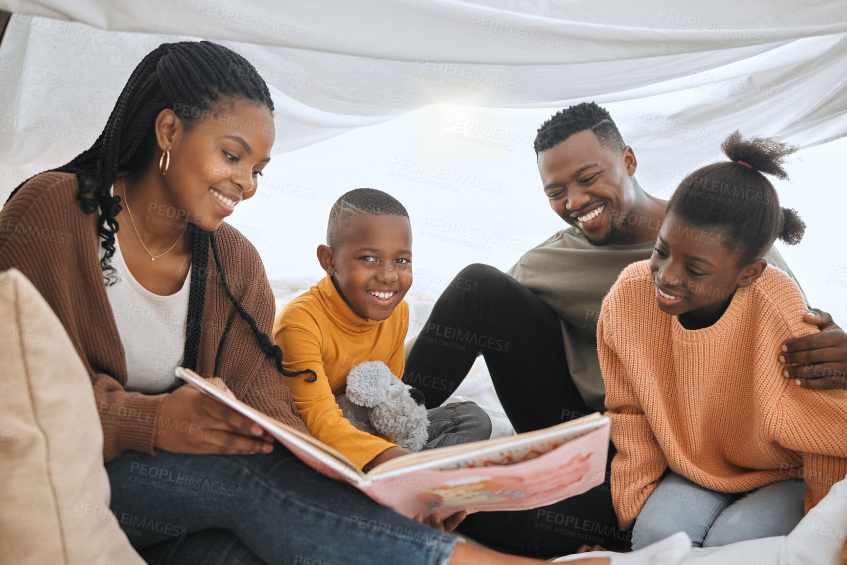 Buy stock photo Shot of a young family reading a story together