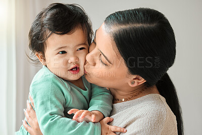 Buy stock photo Shot of a beautiful young woman bonding with her baby at home