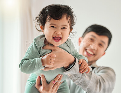 Buy stock photo Shot of a young man bonding with his baby at home