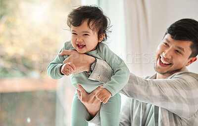 Buy stock photo Shot of a young man bonding with his baby at home